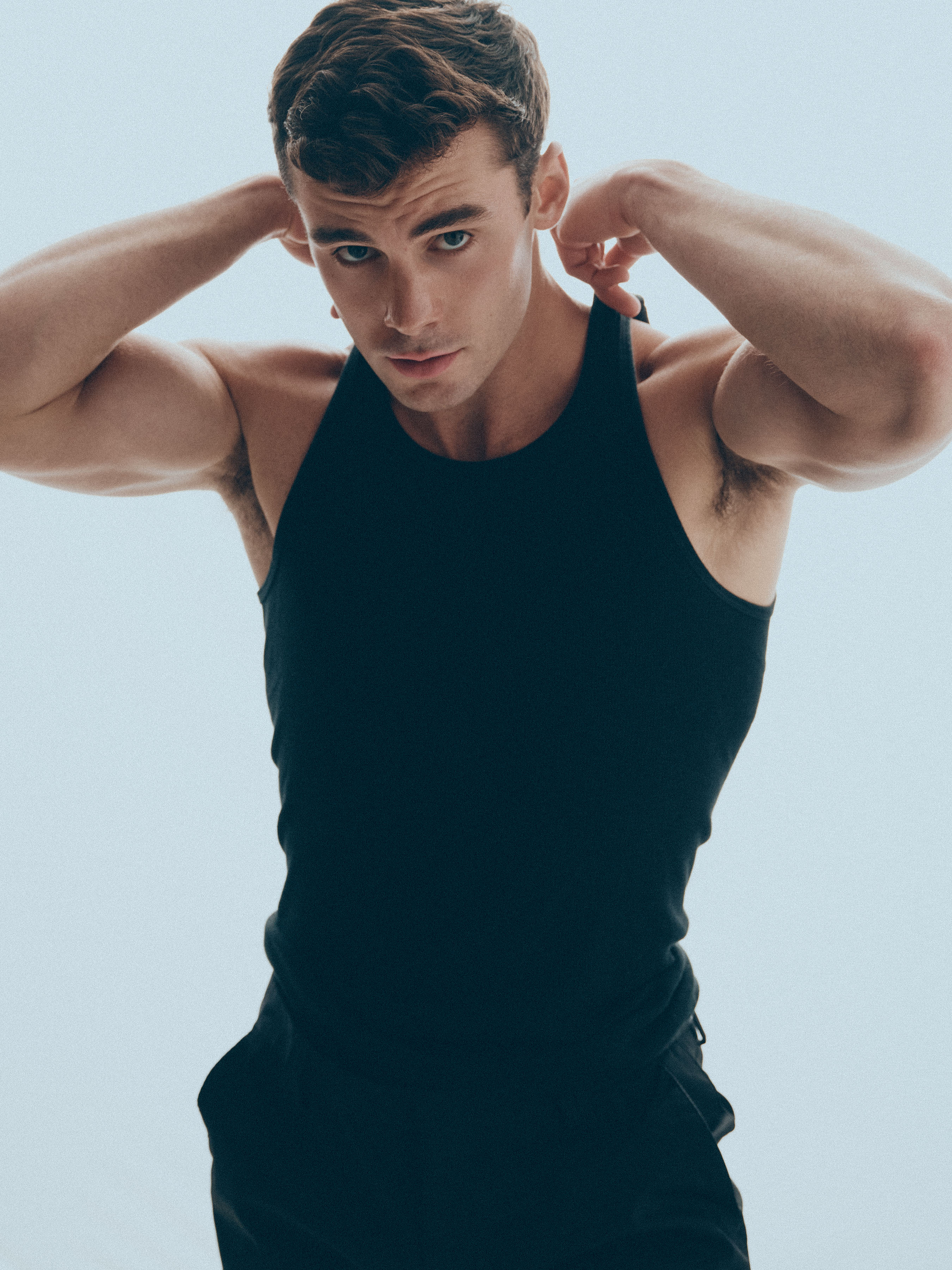 Jake_20_WEB Male model Jake wearing a black tank top photographed in studio during a professional modeling portfolio shoot