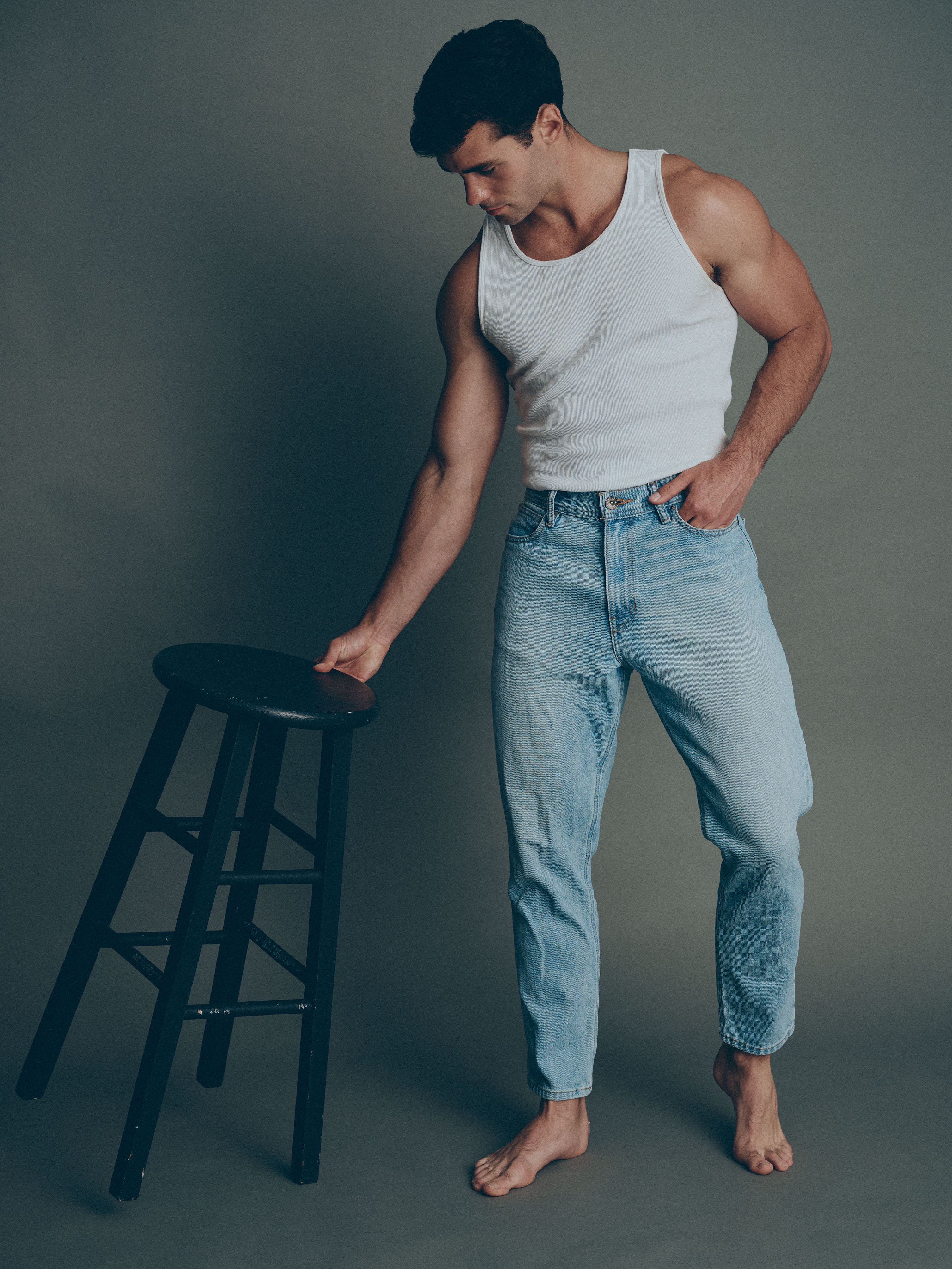 Jake_33_WEB Male model Jake wearing a white tank top and jeans during a professional studio portfolio photoshoot