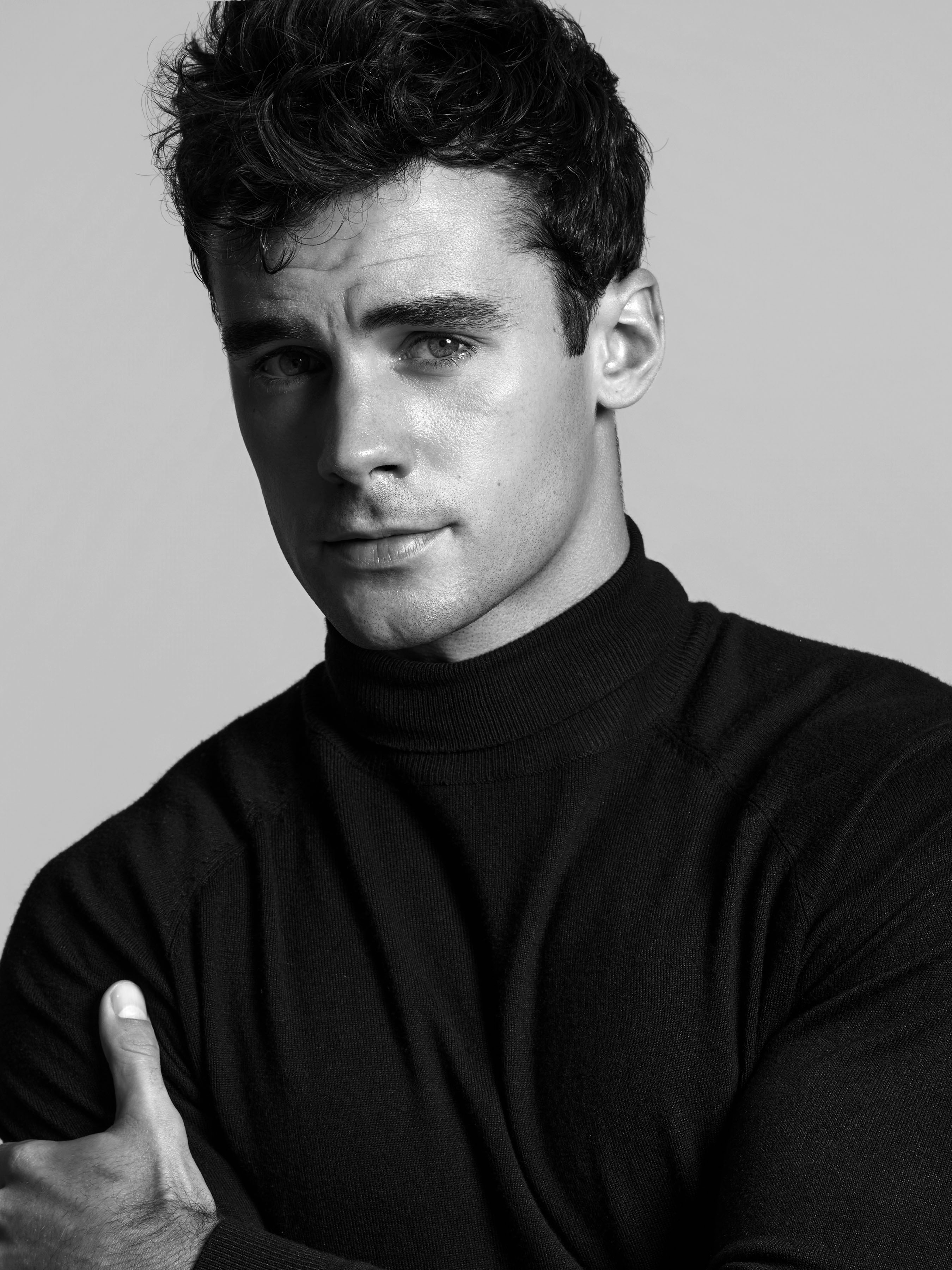 Black and white profile portrait of male model Jake wearing a black turtleneck during a professional studio portfolio shoot